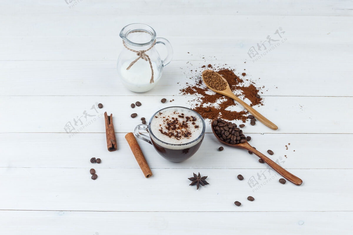 卡布奇诺一套磨碎的咖啡 咖啡豆 肉桂棒 牛奶和咖啡在一个木杯背景上高角度视图质地袋子肉桂
