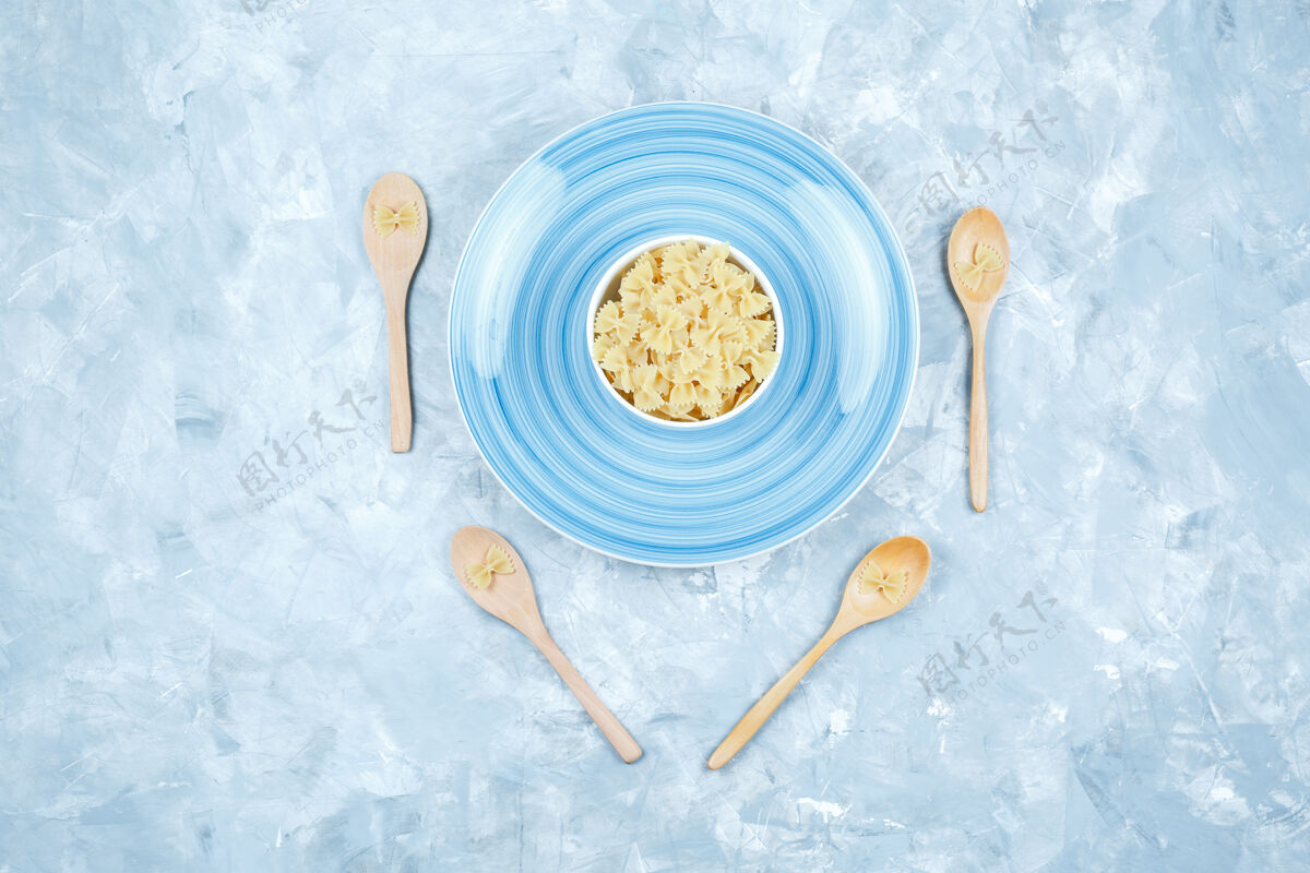 美食顶视图法法尔意大利面在碗和木制勺子与石膏背景板水平晚餐食物干