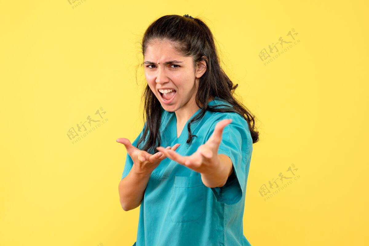 高尔夫正面图愤怒的女医生穿着制服站在黄色孤立的背景上听诊器肖像人物