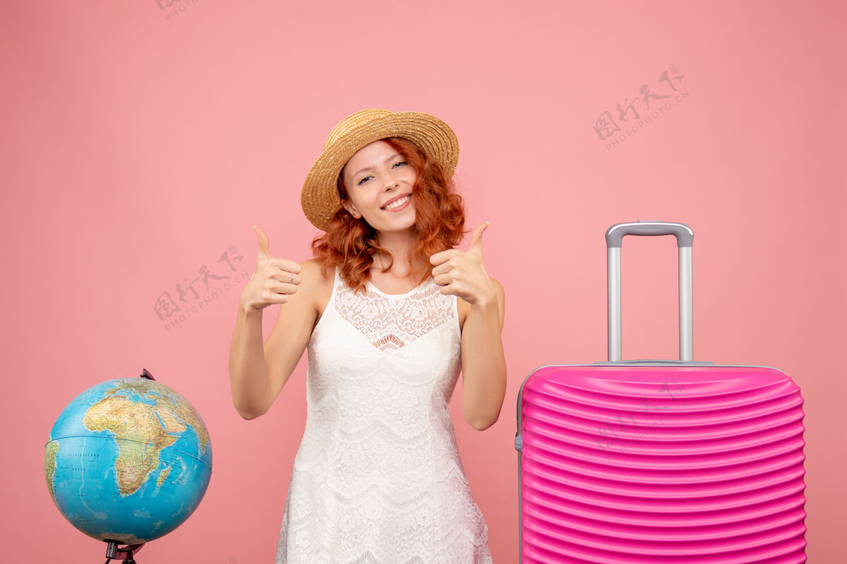 模特年轻女性游客的正面图 粉红色的墙上挂着粉红色的包包前面假期