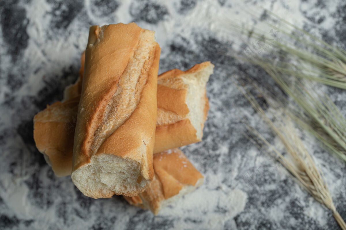 法式面包白色背景上新鲜出炉的法式面包片俯视图面包法国烹饪