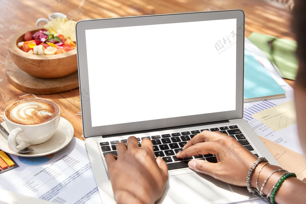 显示器黑皮肤女人的后视图坐在打开的笔记本电脑前 空白的白色屏幕为您的广告在线打字显示器