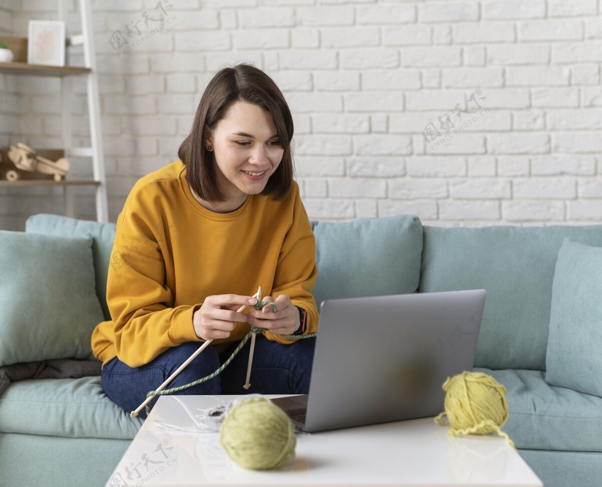 笔记本电脑中等身材的女人在家里编织生活方式设备内