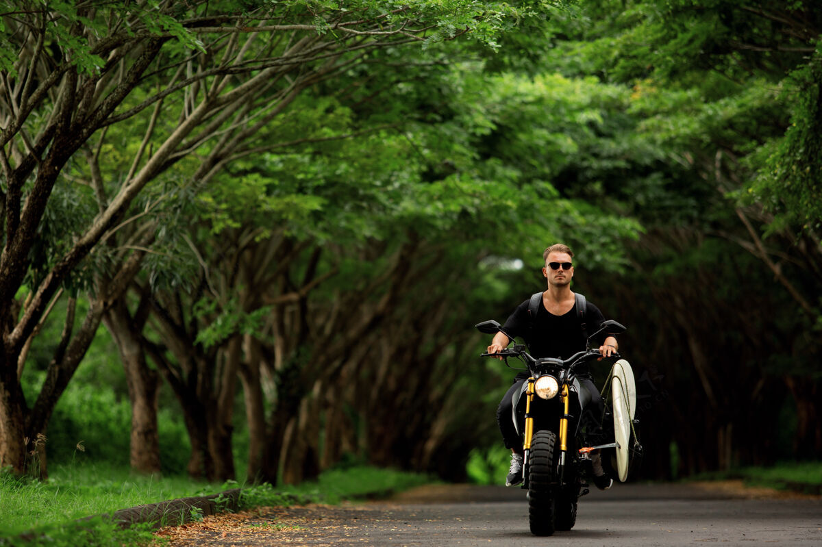 自由年轻人骑着摩托车和冲浪板冲浪摩托车手景观