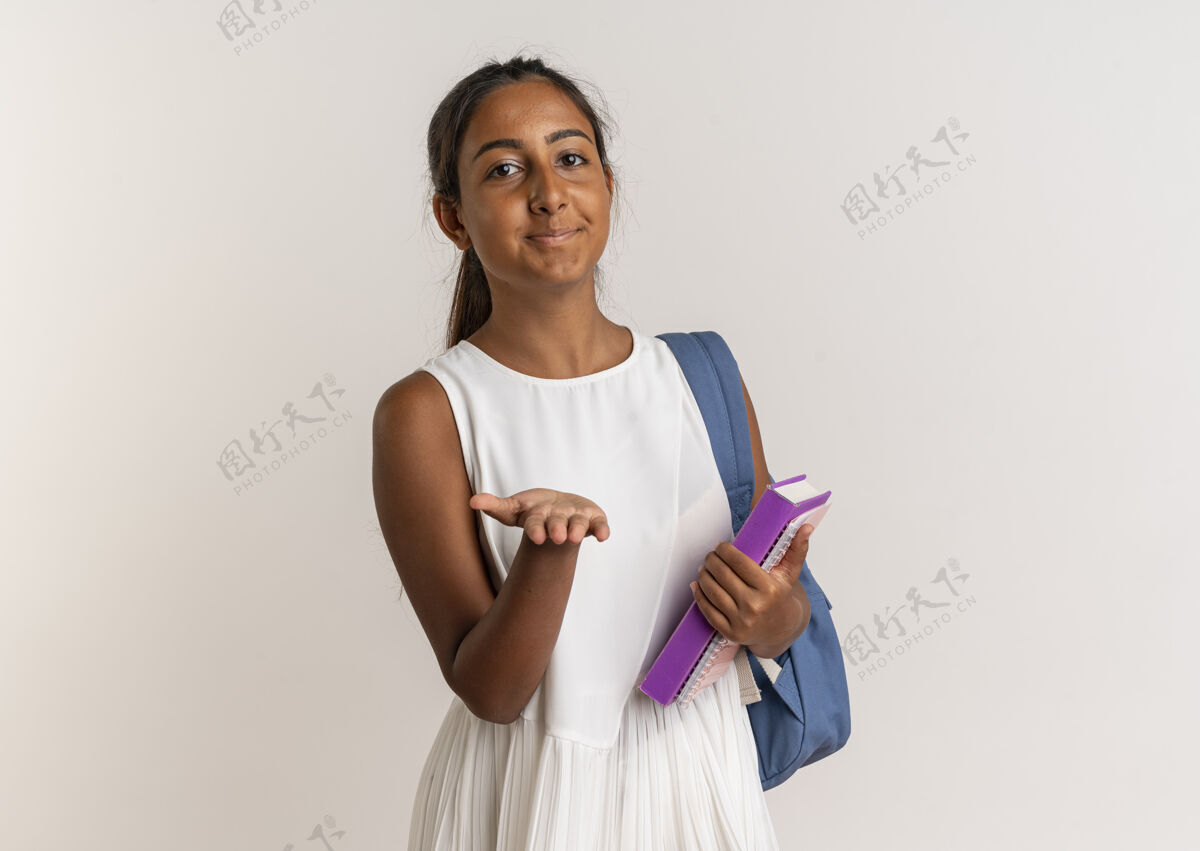 手高兴的小女生背着书包拿着书 伸出手孤立在白墙上背包请穿