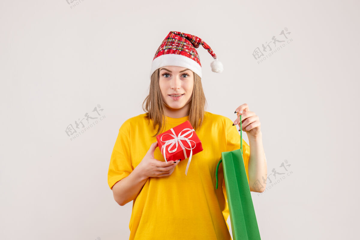 帽子年轻的女性拿着包裹和白色的小礼物年轻女性人购物