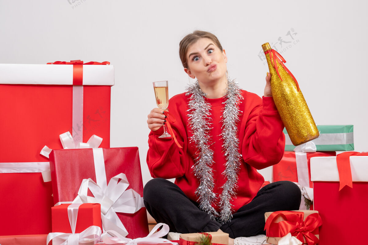 女人漂亮的女人围坐在圣诞礼物旁 用白色香槟庆祝香槟礼物购物
