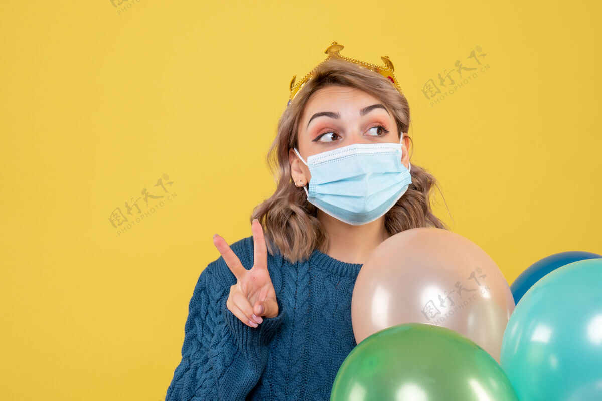 消毒年轻的女性拿着黄色的无菌面具气球医学观点气球