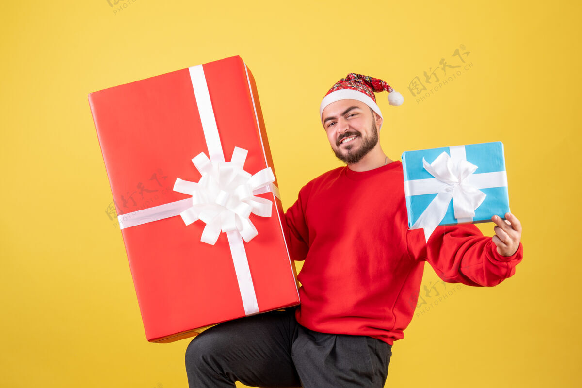 购物正面图黄色背景上的年轻男性圣诞礼物礼物卡通人