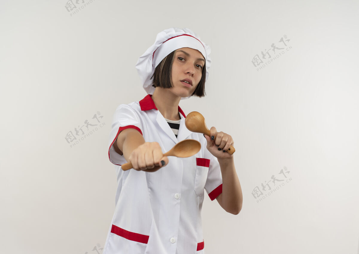 拿着自信的年轻女厨师 身着厨师制服 手拿勺子 伸出勺子 勺子与白色隔开 留有复印空间空间信心复制