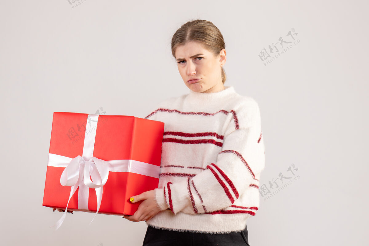 礼物年轻的女性拿着白色的红色礼物情绪红色圣诞节