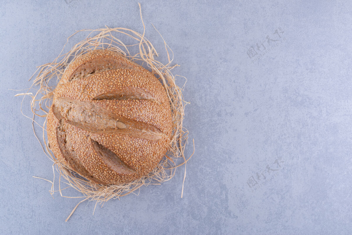 酵母一个面包放在大理石表面的稻草堆上正餐面包面包屑