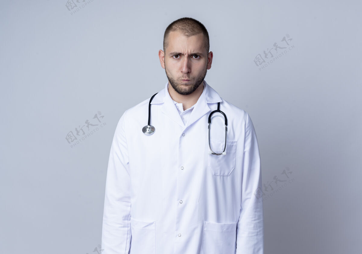 穿皱眉的年轻男医生 穿着医用长袍 脖子上戴着听诊器 站在白色的空间里 看上去与世隔绝医疗太空周围