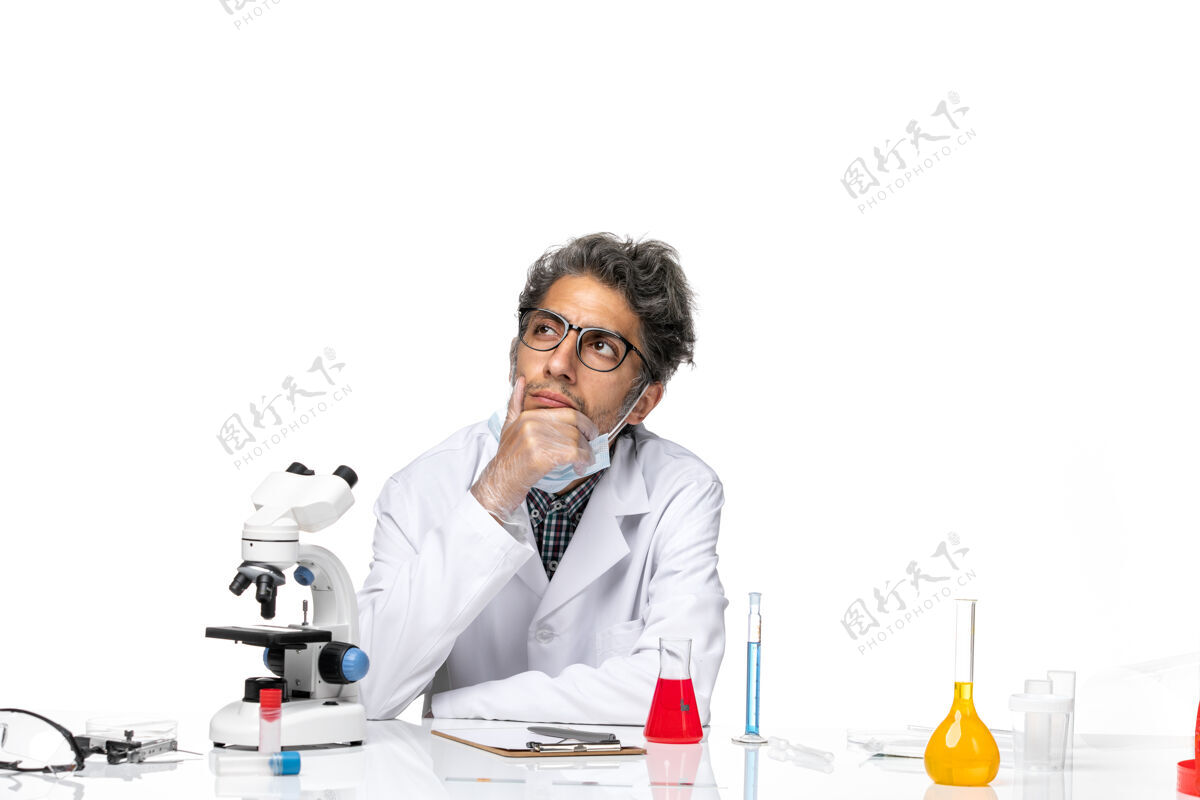 周围正面图中年科学家穿着特制的白色西服围坐在桌子旁思考解决方案病毒解决方案前面