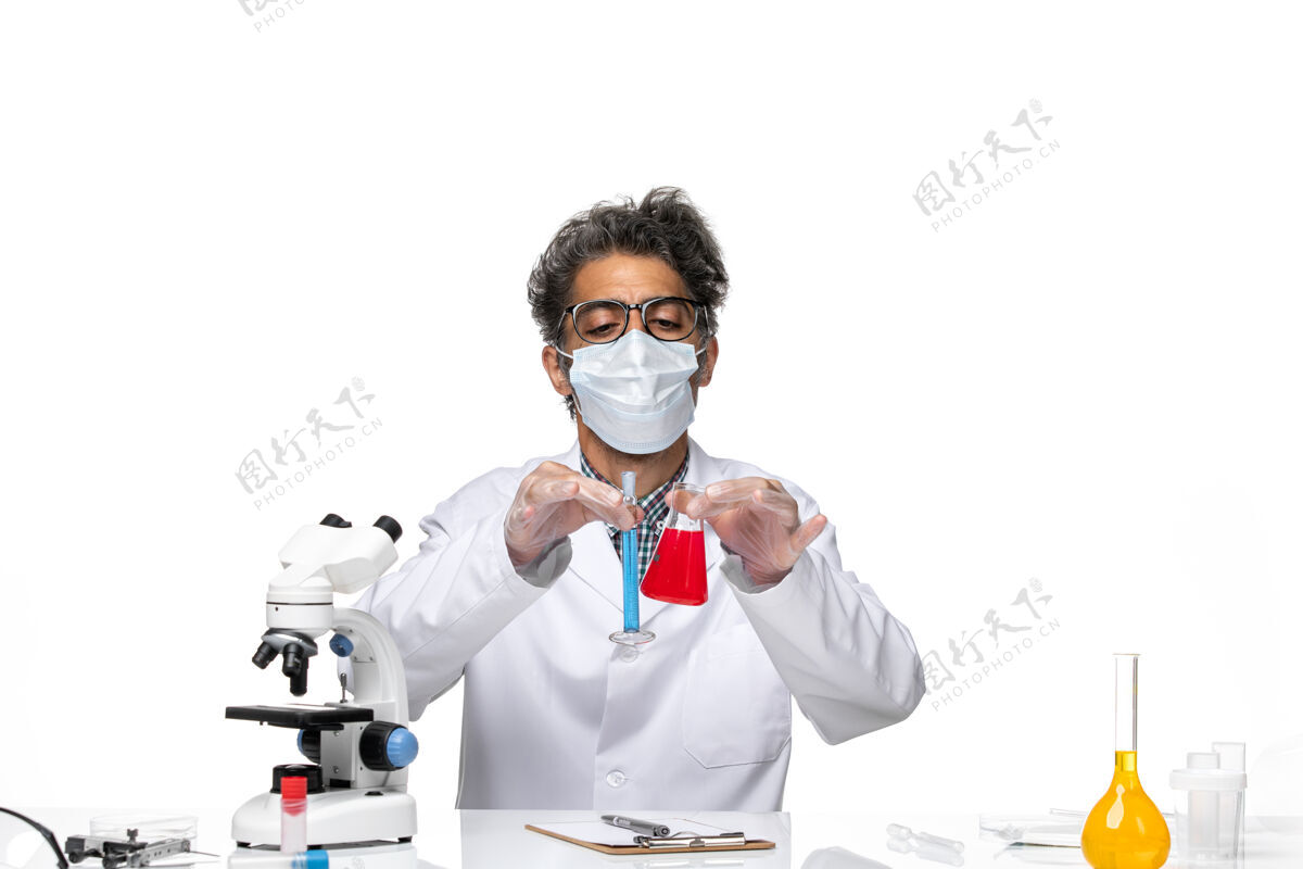 科学正面图穿着特殊套装的中年科学家坐着拿着装有解决方案的烧瓶外套人实验