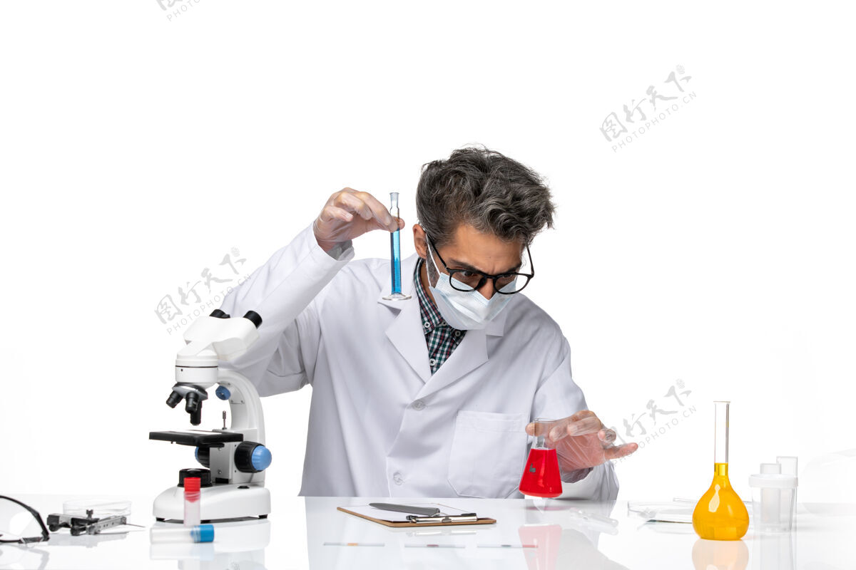 溶液正面图穿着特殊套装的中年科学家坐着拿着装有解决方案的烧瓶男科学实验室