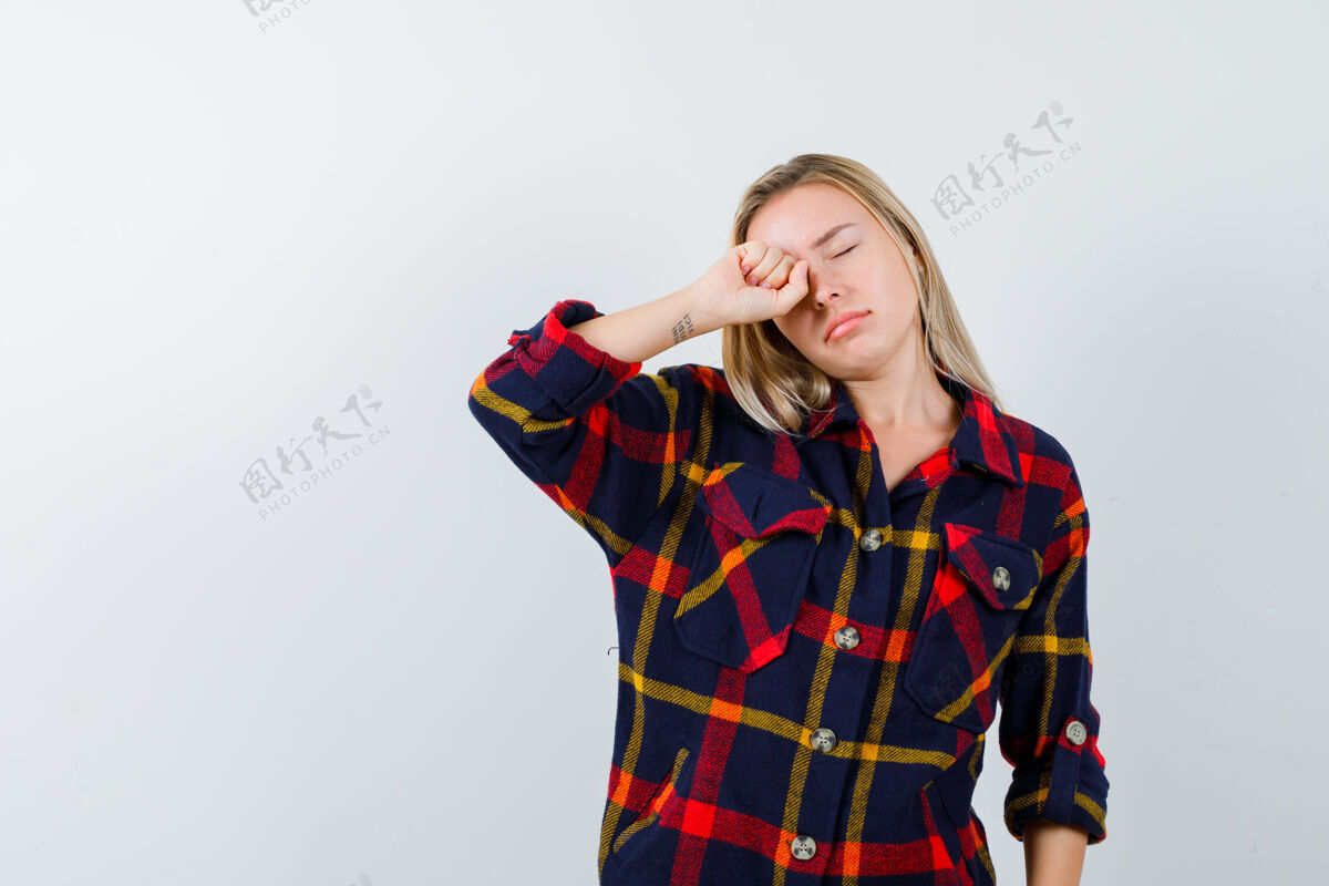 完美穿着格子衬衫的年轻女士揉着眼睛 看起来很困倦 前视图护理清洁检查