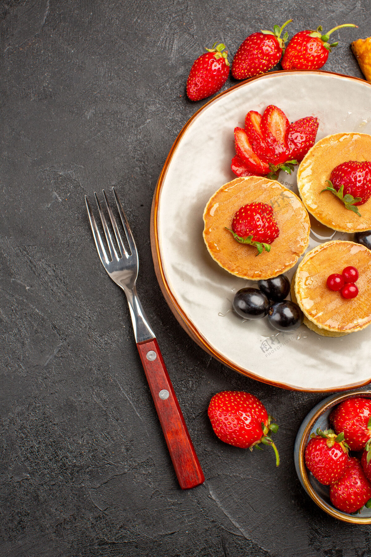 营养品俯瞰美味的薄饼与水果在黑暗的表面馅饼水果蛋糕甜蛋糕草莓新鲜