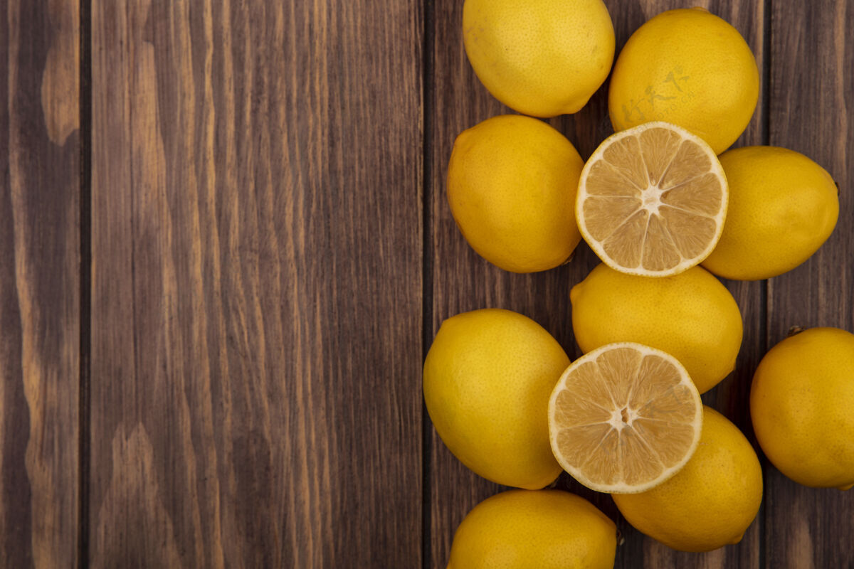 切片顶视图多汁的半个和整个柠檬孤立在一个木制墙壁与复制空间多汁景观整个