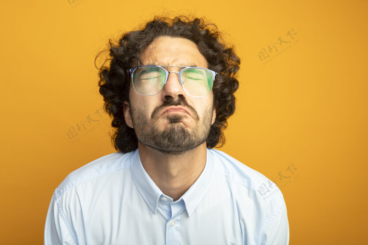年轻年轻英俊的白人男子戴着橙色背景隔离眼镜的特写镜头戴男人橙色