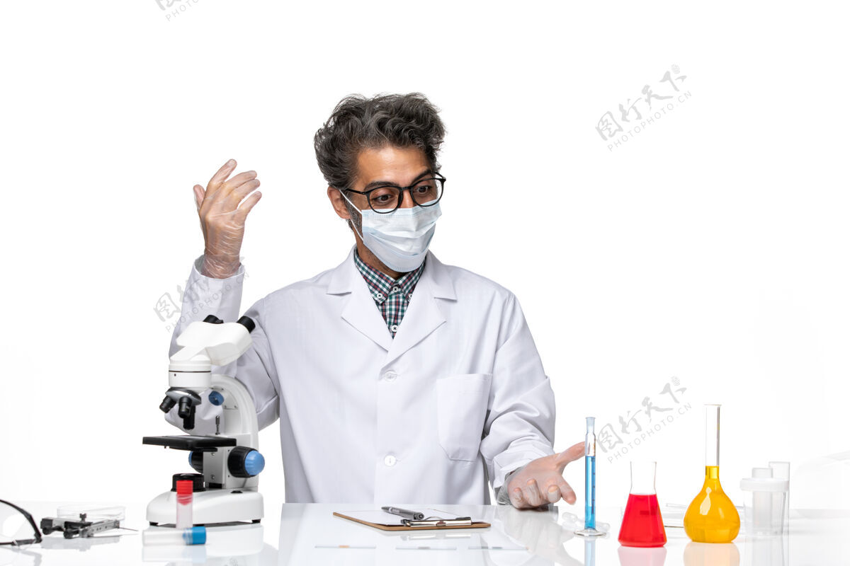化学正面图身着特殊套装的中年科学家坐着写笔记笔记实验科学