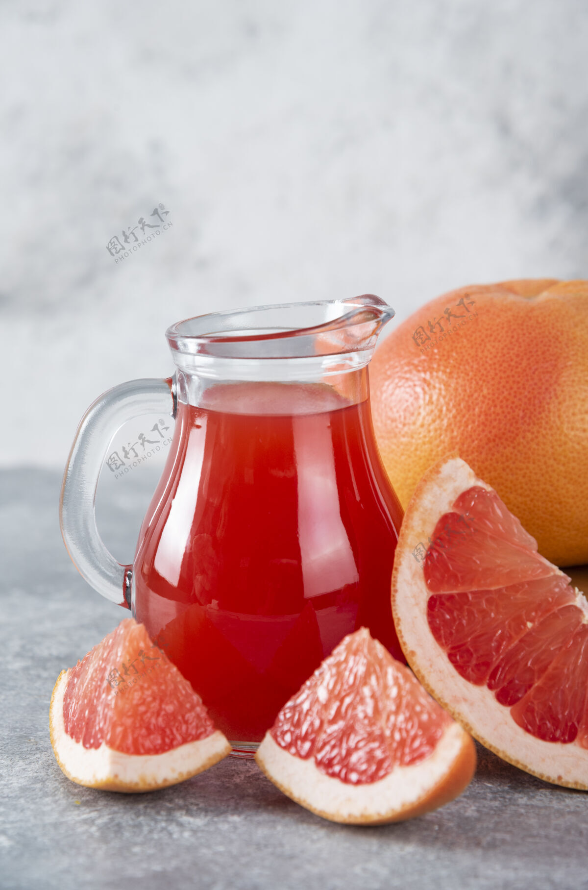 酸一大罐新鲜葡萄柚汁和水果片五颜六色柑橘餐桌