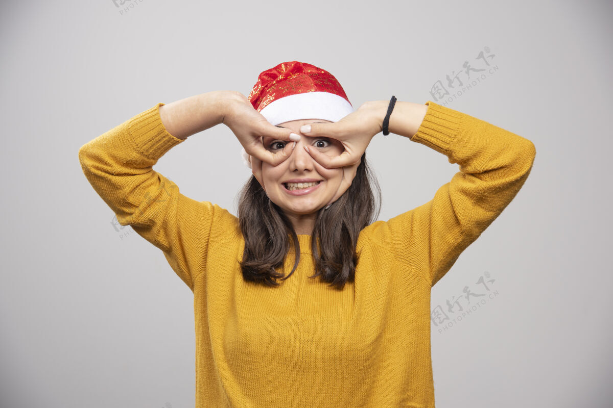 黑发戴圣诞帽的女人在展示她的瞳孔表情肖像女孩