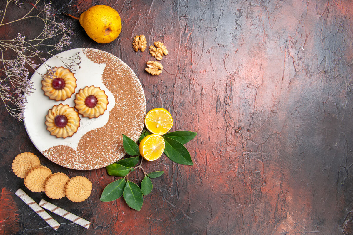 橘子俯视图美味的小饼干与水果在黑暗的桌子糖蛋糕甜饼干深色叶子健康