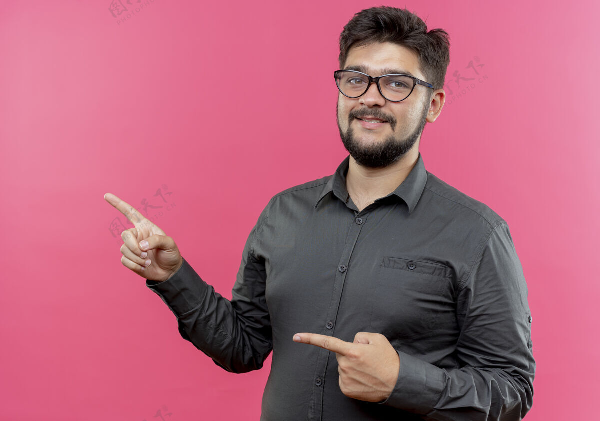 年轻人高兴的年轻商人戴着眼镜点在一旁 隔离在粉红色的墙上 留着复印空间穿请点