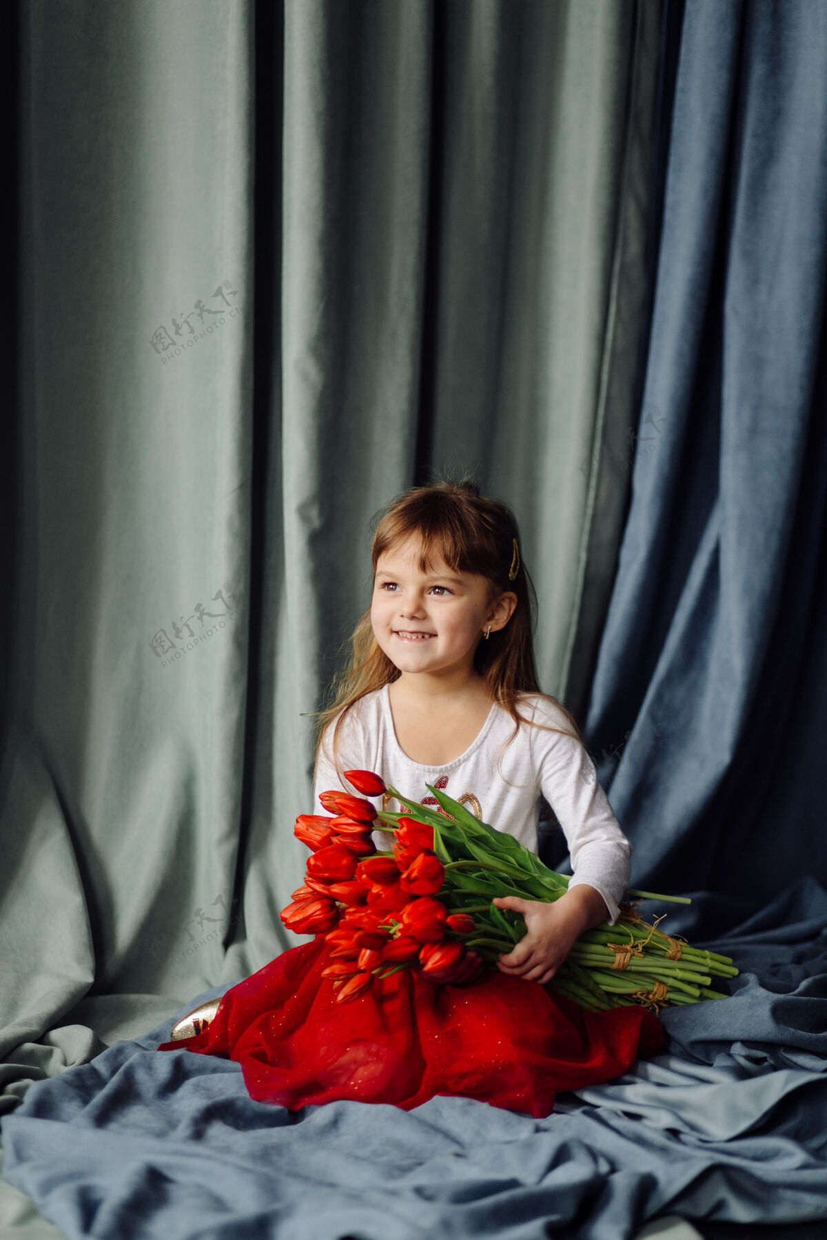 花带着一束红郁金香的小女孩孩子举行脸