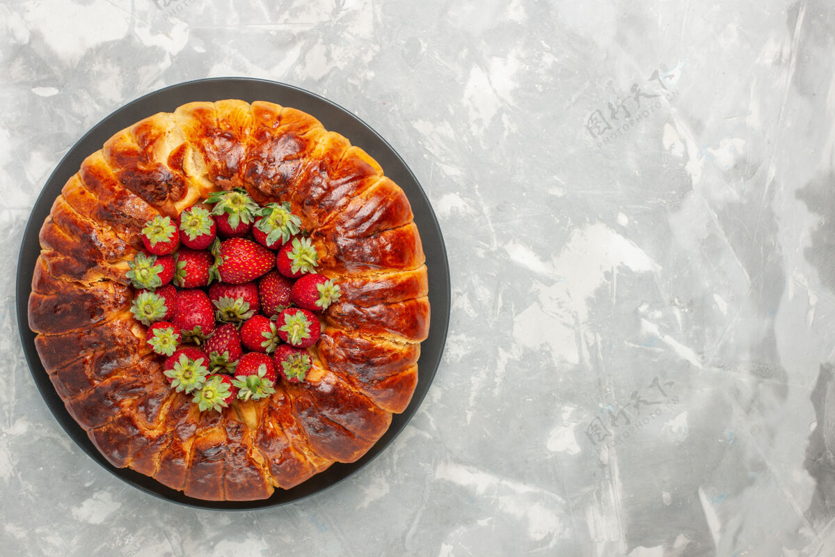生的白色表面有新鲜红色草莓的美味草莓派俯视图糖果美味盘子