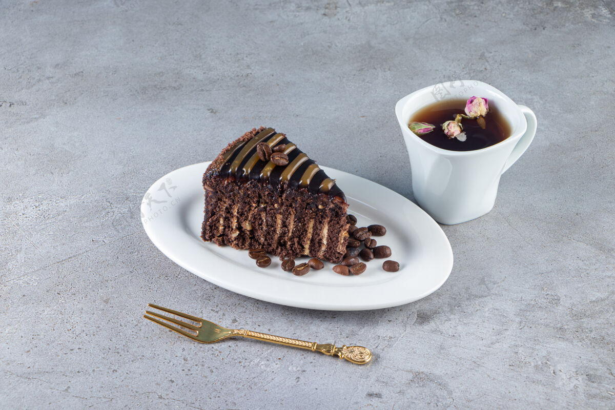 小块在石桌上放一片巧克力蛋糕和一杯茶奶油烘焙面包房