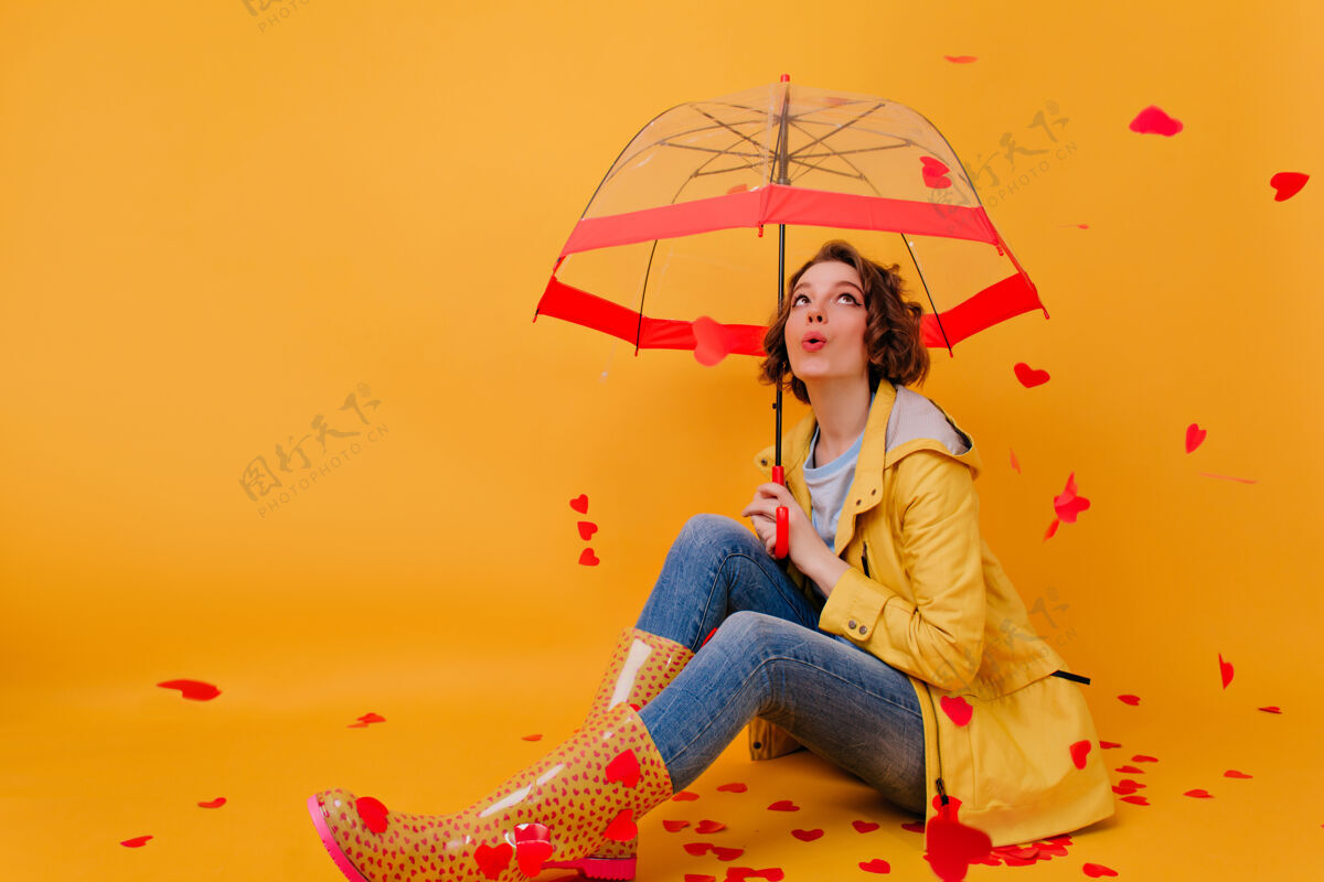 季节带着雨伞的白人女孩在心雨下摆姿势在情人节这天 可爱的年轻女子在摄影棚拍照室内阳伞雨