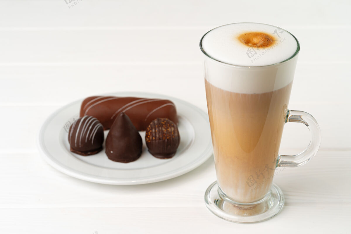 巧克力在木桌上放一杯咖啡和带巧克力糖的碟子含糖杯子甜点