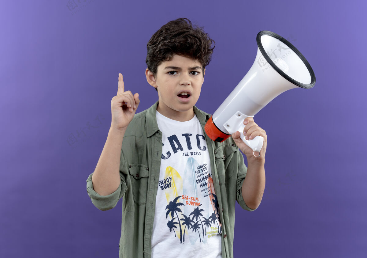 小学生印象深刻的小男生拿着扩音器 指着紫色的墙上孤立起来墙喇叭尖