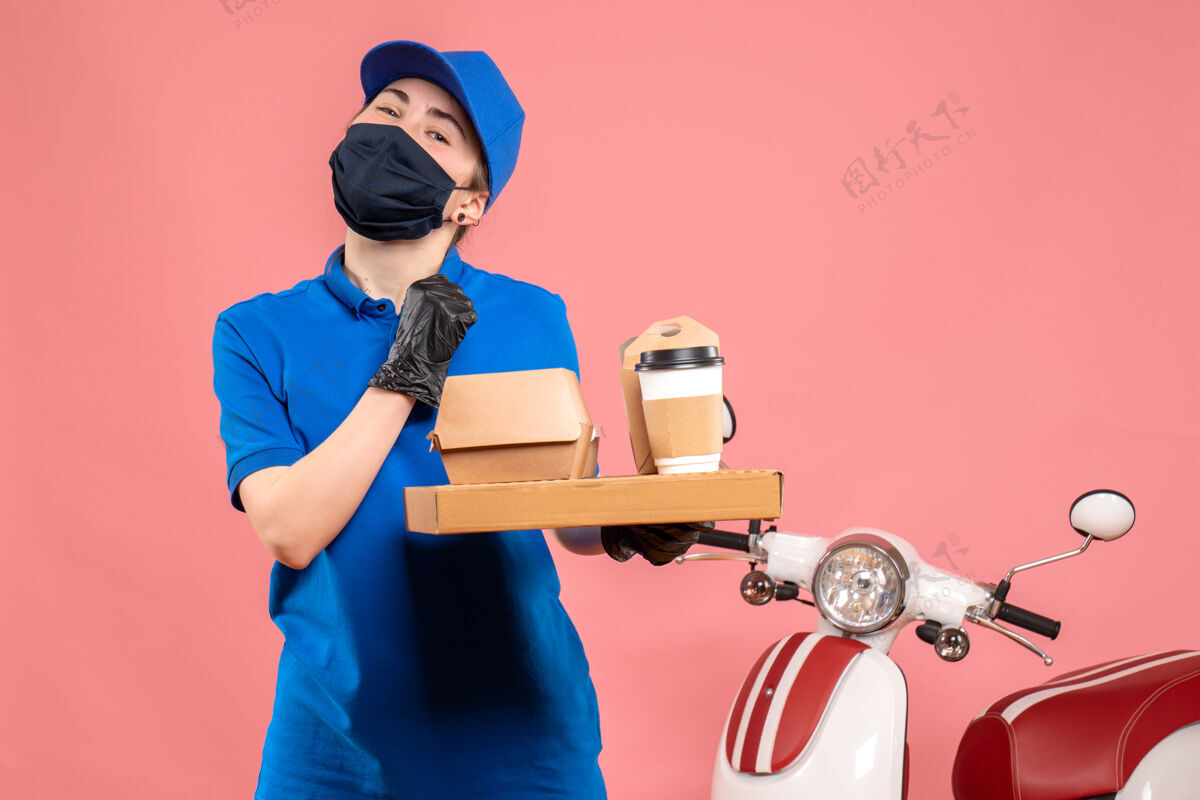 人正面图：戴着面具的女快递员 粉色的咖啡和食物专业人员送货护目镜