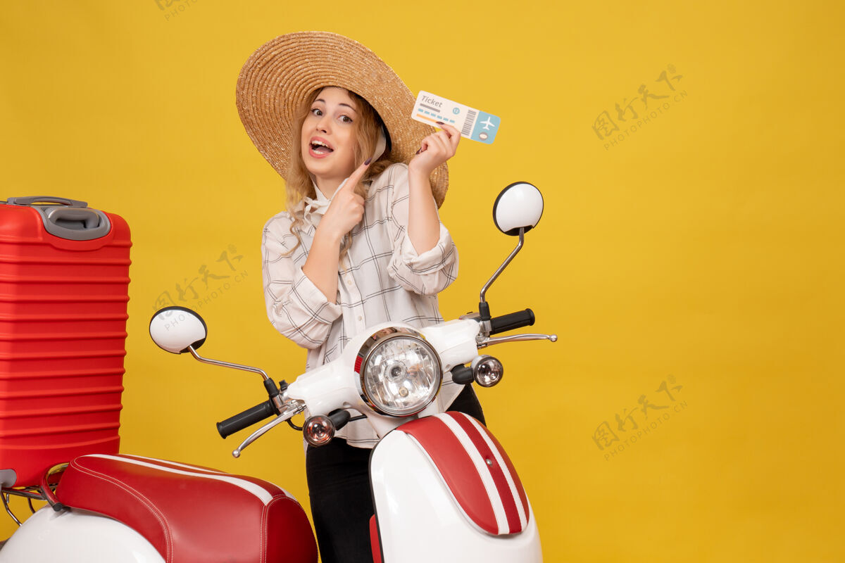 车辆前视图雄心勃勃的年轻女子戴着帽子 坐在摩托车上收拾行李 出示车票帽子成人微笑