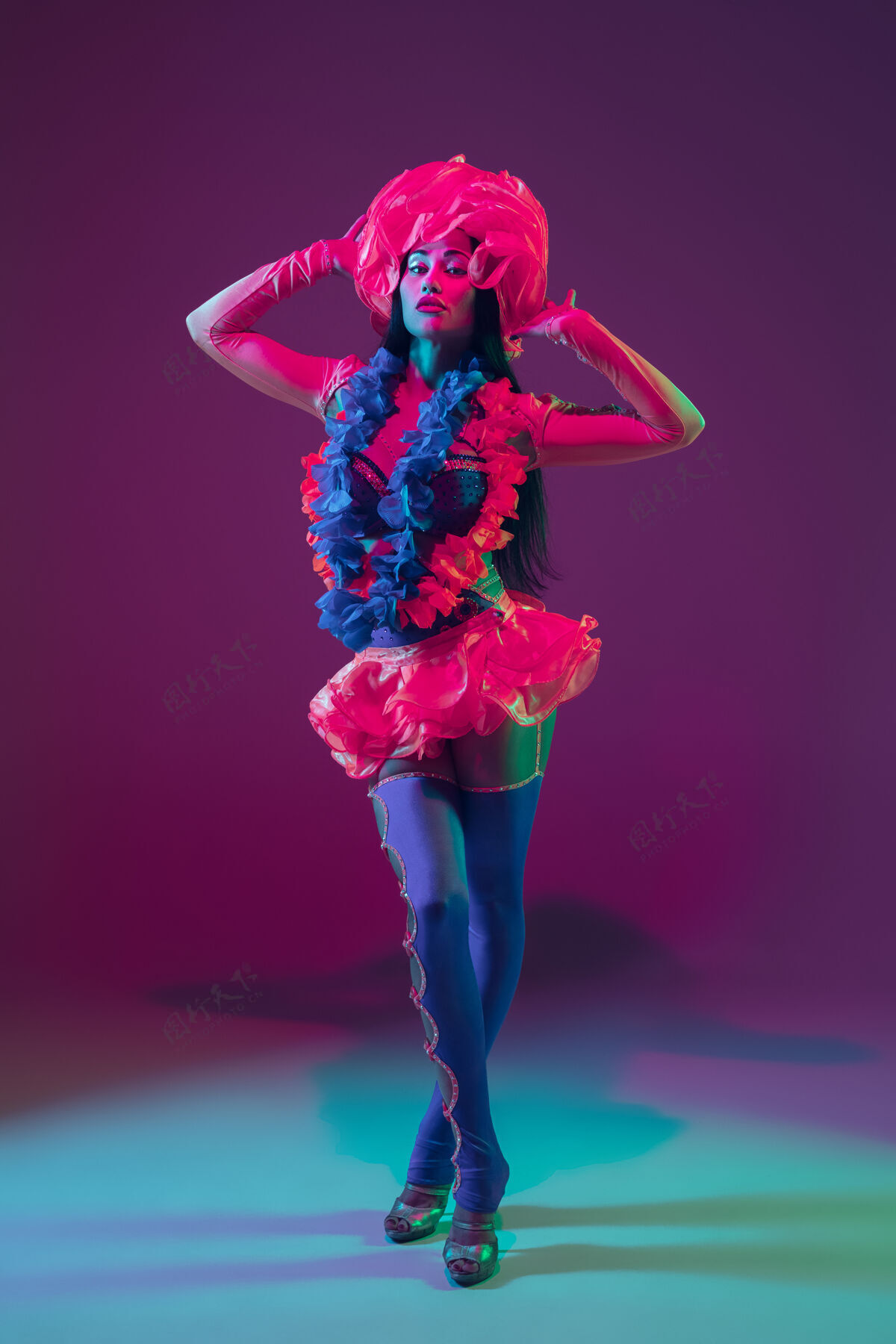 美女迷人的夏威夷黑发模特在霓虹灯下的紫色工作室墙上舞蹈黑发微笑