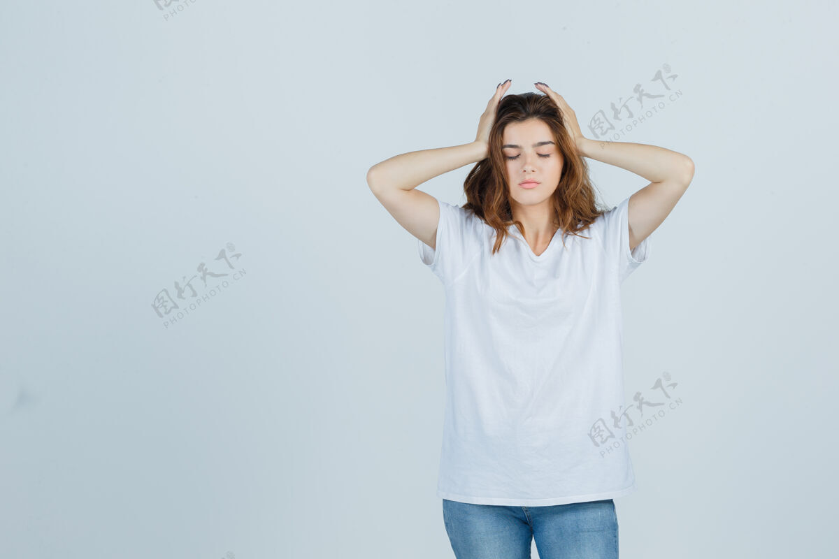 魅力年轻女士手举着头 穿着t恤 牛仔裤 看起来很累前视图人护理女性