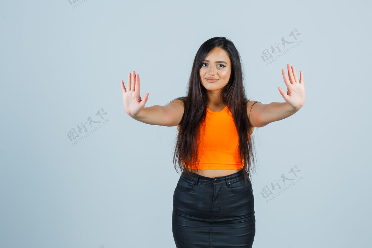 皮肤年轻的女士在单身 迷你裙展示手掌 看起来很自信前视图护理头发单身