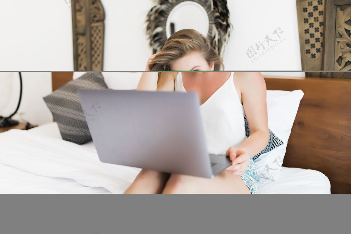房子年轻女子在卧室里用笔记本电脑女模特在床上用笔记本电脑工作人坐着购买