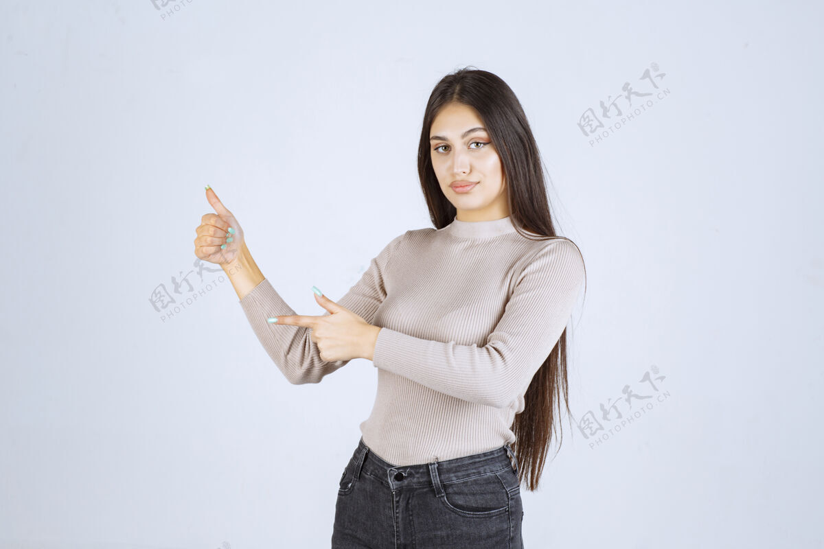 成功穿灰色毛衣的女孩在做竖起大拇指的招牌成人员工人类