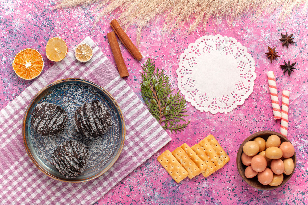 糖果顶视图美味的巧克力蛋糕糖果和薯片上的粉红色鸡蛋肉桂饼干