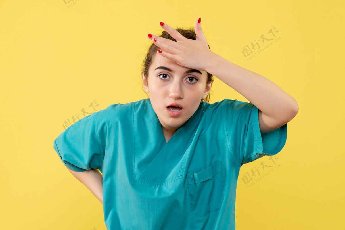 女医生黄色墙壁上穿着医疗服的女医生的正视图套装医院医疗