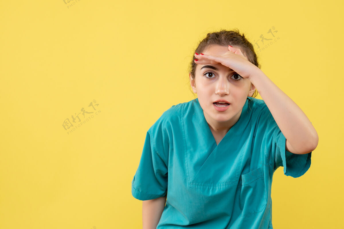 病毒黄色墙上穿着医疗服的女医生的正视图头饰肖像正面