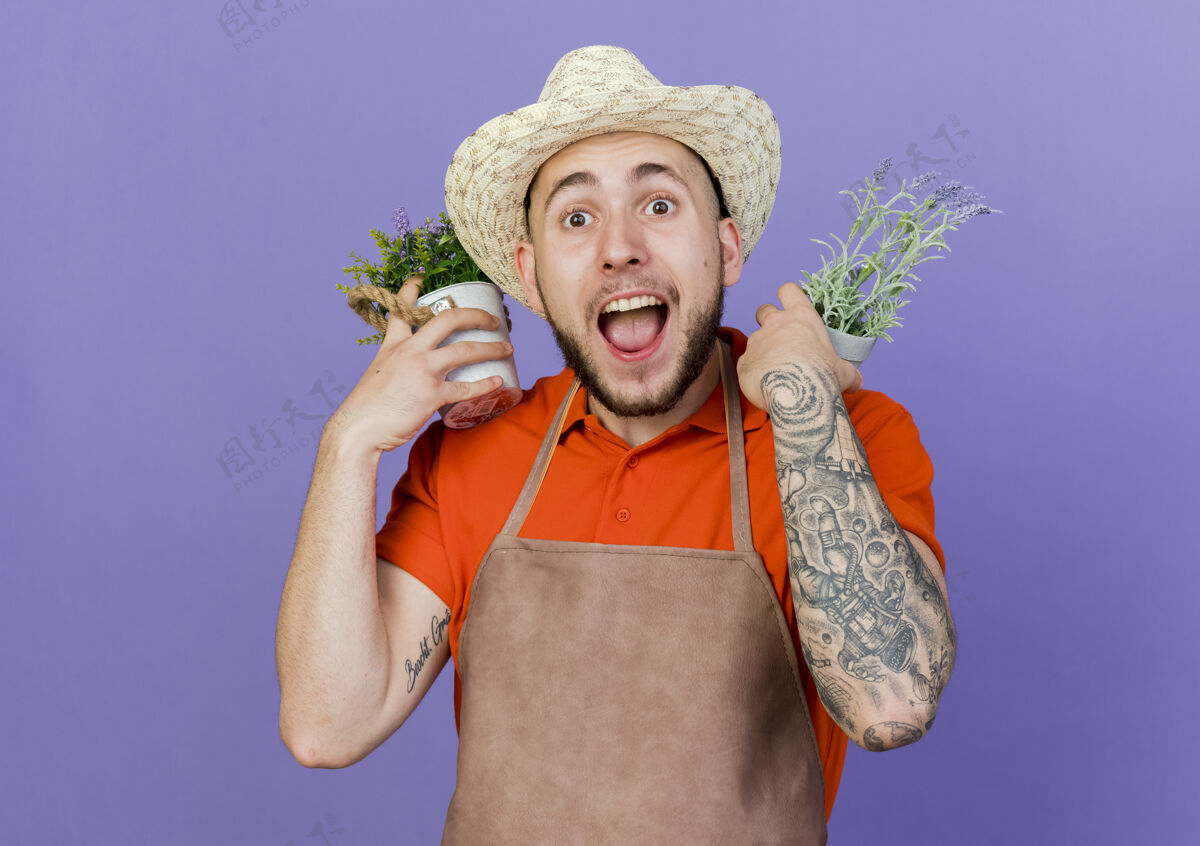 帽子惊讶的男园丁戴着园艺帽 肩上扛着花盆复制紫色惊喜