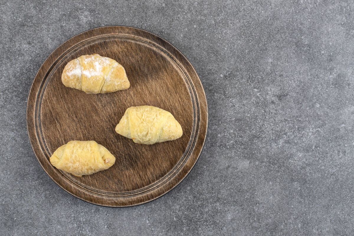 面包房大理石桌上放着木板和自制的新鲜饼干自制面包皮糕点