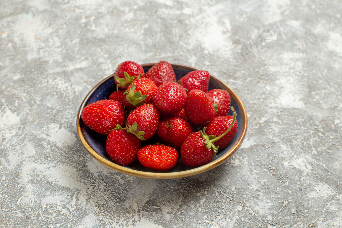 水果正面图新鲜的红色草莓放在盘子里 白色桌上 红色浆果新鲜可食用水果甜点健康