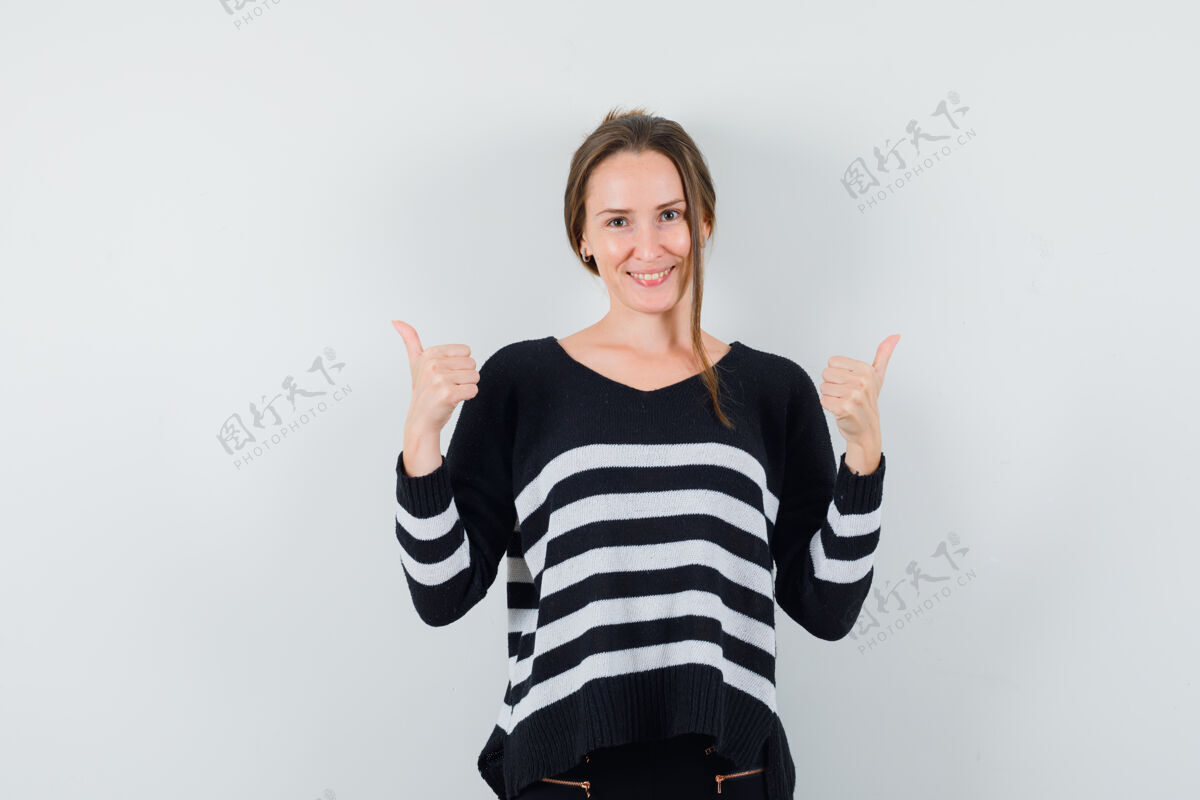 自然穿着休闲衬衫的年轻女士竖起大拇指 看起来很开心时尚前面休闲