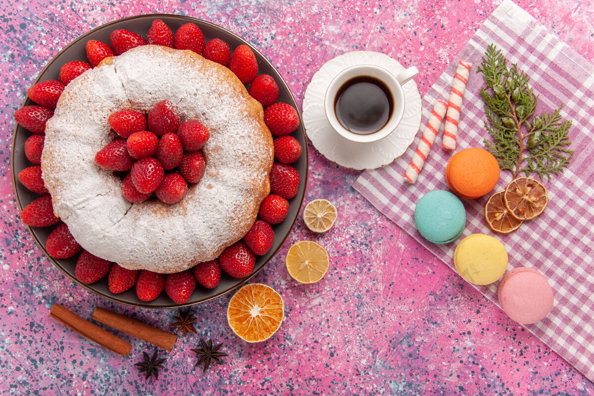 传统顶视图糖粉派草莓蛋糕与法国马卡龙粉红小吃健康食物